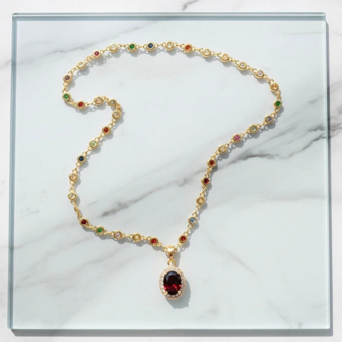 Gold necklace with gemstones on a marble surface