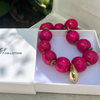 Pink beaded necklace with gold accents on a white box, branded 'CF Hristy F Collection'.
