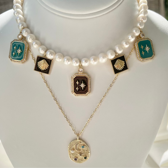 Pearl necklace with decorative pendants on a mannequin bust.