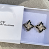 Black and silver earrings in a box with 'The Christy F Collection' branding.