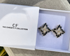 Black and silver earrings in a box with 'The Christy F Collection' branding.