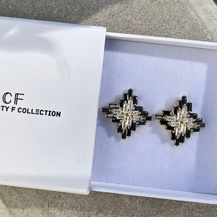 Black and silver earrings in a box with 'The Christy F Collection' branding.