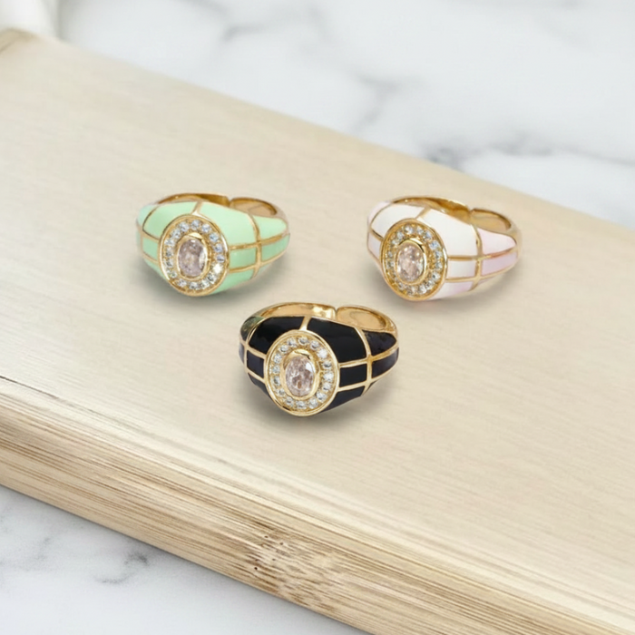 Three decorative rings with gemstones on a wooden surface.