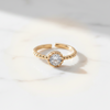 Gold ring with a diamond on a light gray background