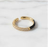 Gold and black ring with diamond accents on a white background