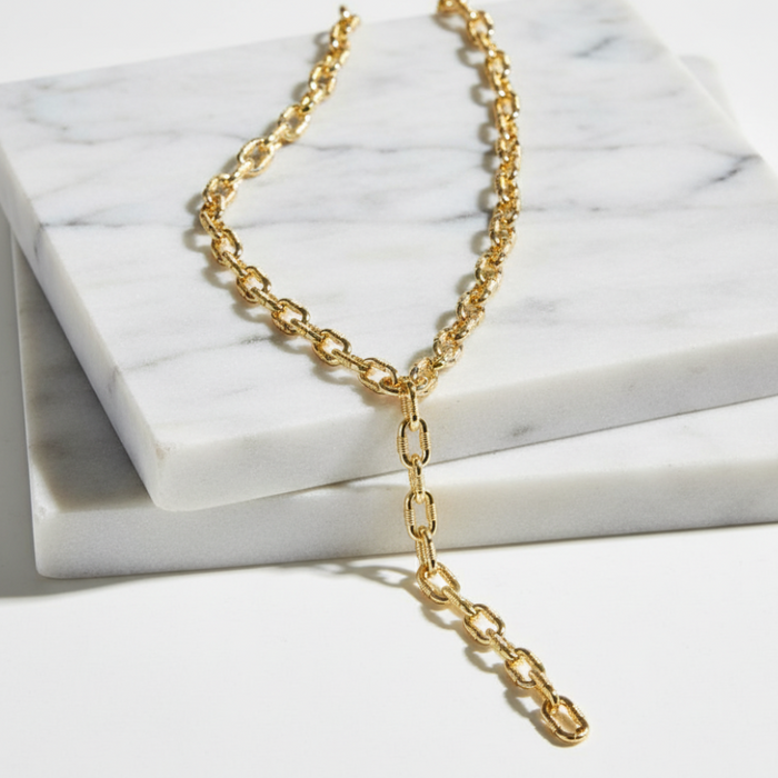 Gold chain necklace on a marble surface