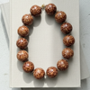 Necklace with brown beads on a light gray surface