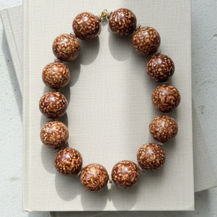 Necklace with brown beads on a light gray surface