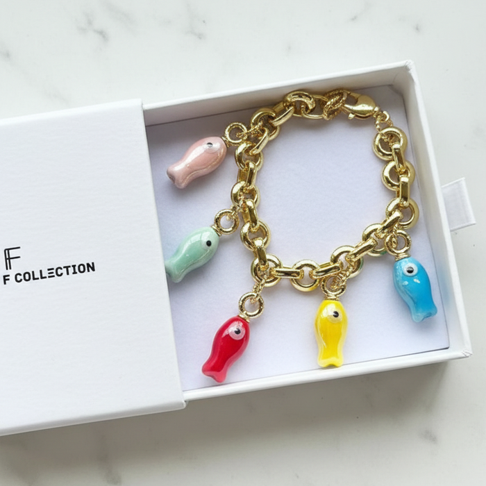 Gold chain bracelet with colorful fish charms in a box labeled 'CF Collection'.
