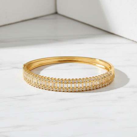 Gold bracelet with clear stones on a white surface