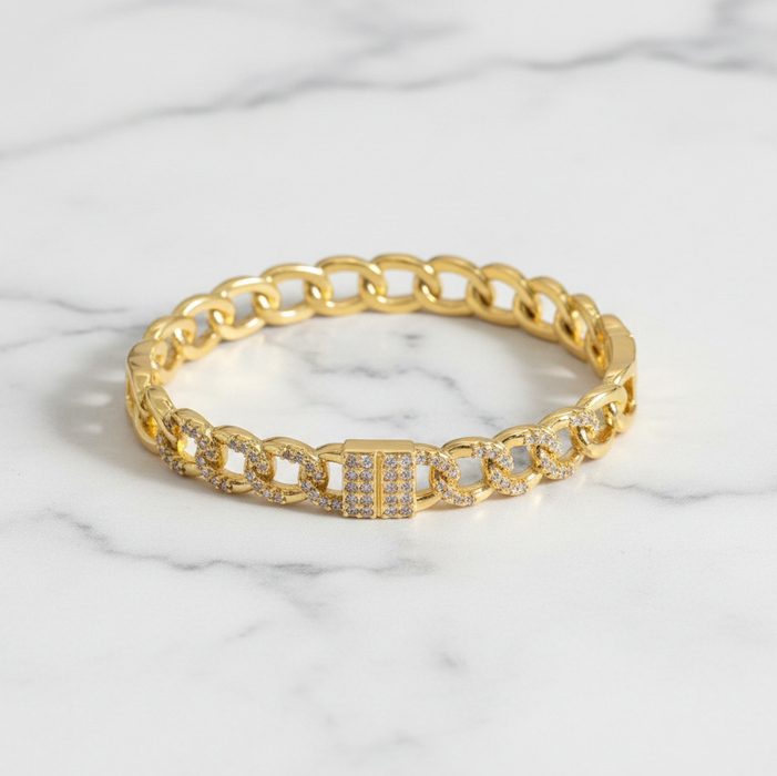 Gold bracelet with diamond accents on a marble surface