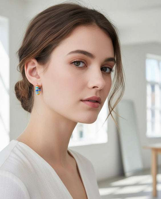 Woman wearing colorful earrings in a bright room