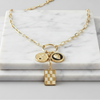 Gold necklace with charms on a marble surface