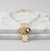 Gold necklace with charms on a marble surface