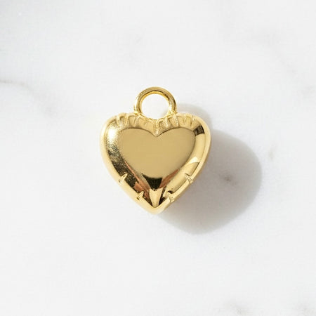 Gold heart-shaped pendant on a white background