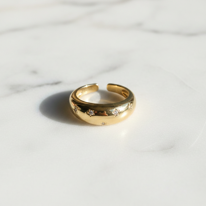 Gold ring with small stones on a marble surface