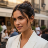Woman in a white blazer standing in an outdoor urban setting