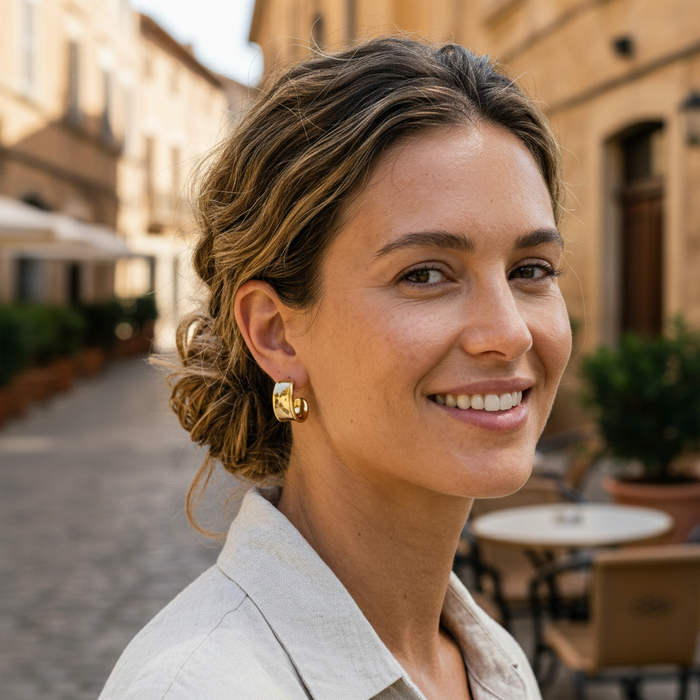 Woman smiling outdoors with a blurred street and buildings in the background