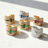 Set of gold and silver rings with gemstone accents on a white surface.