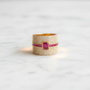 Gold ring with a red gemstone on a light gray background