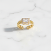 Gold ring with a diamond on a marble surface