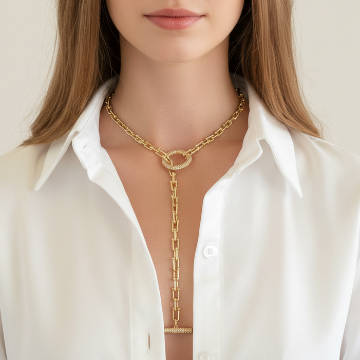 Gold chain necklace worn by a person with a white shirt