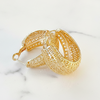 Gold earrings on a marble surface