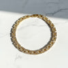 Gold diamond necklace with clear stones on a marble surface
