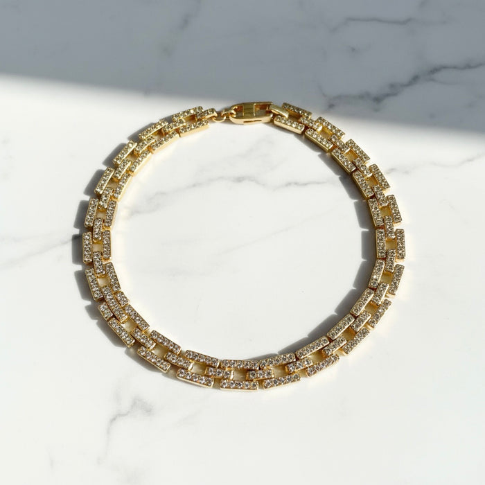 Gold diamond necklace with clear stones on a marble surface