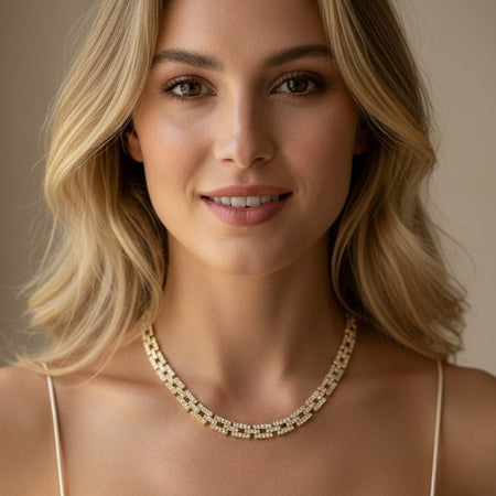 Woman wearing a gold necklace against a neutral background