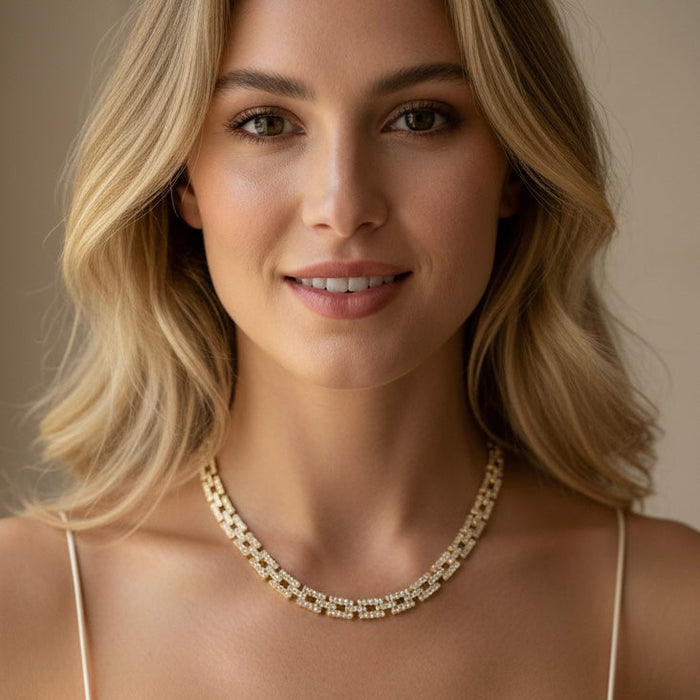 Woman wearing a gold necklace against a neutral background