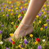 Foot wearing a anklet in a field of colorful flowers