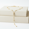 Gold necklace on a white box with a white background