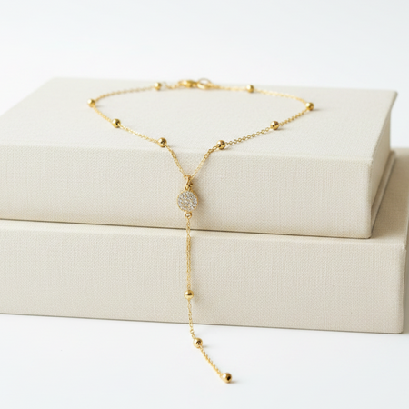 Gold necklace on a white box with a white background