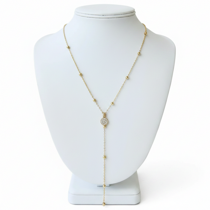Gold beaded necklace on a white mannequin bust