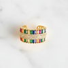 Multicolored beaded ring with gold accents on a white background