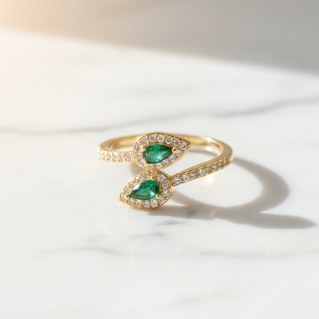Gold ring with emerald stones on a white background
