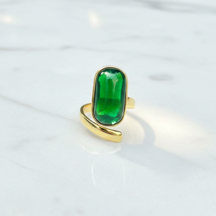 Gold ring with a green gemstone on a white background