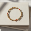 Multicolored beaded bracelet on a white card with a marble background