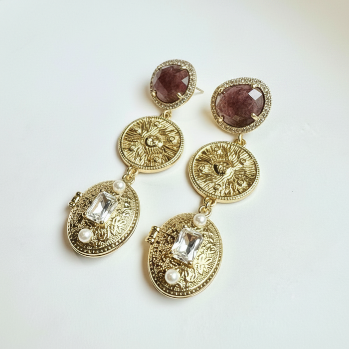 Gold earrings with gemstones on a white background