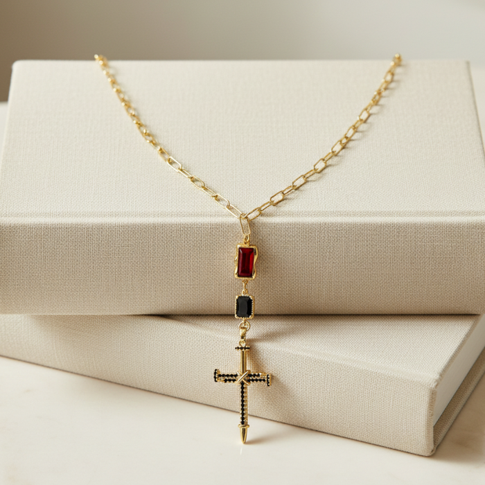 Gold necklace with a cross pendant on a beige box