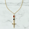 Gold necklace with a cross pendant on a marble background