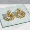 Gold hoop earrings on a marble surface