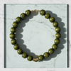 Green beaded necklace on a marble surface