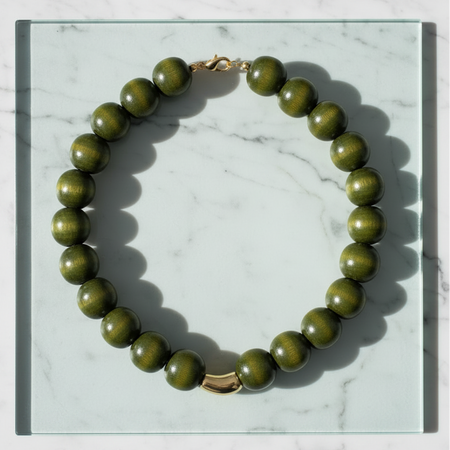Green beaded necklace on a marble surface