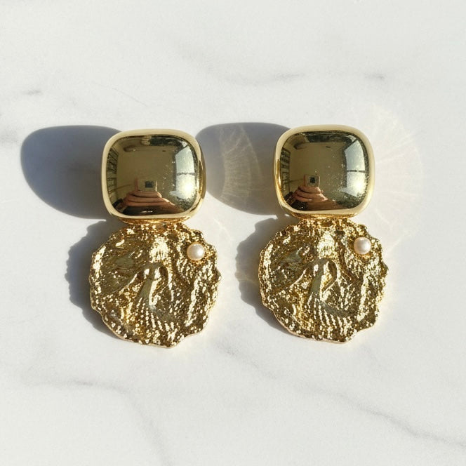 Pair of gold earrings on a white background