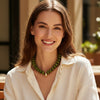 Woman wearing a green necklace in an outdoor setting