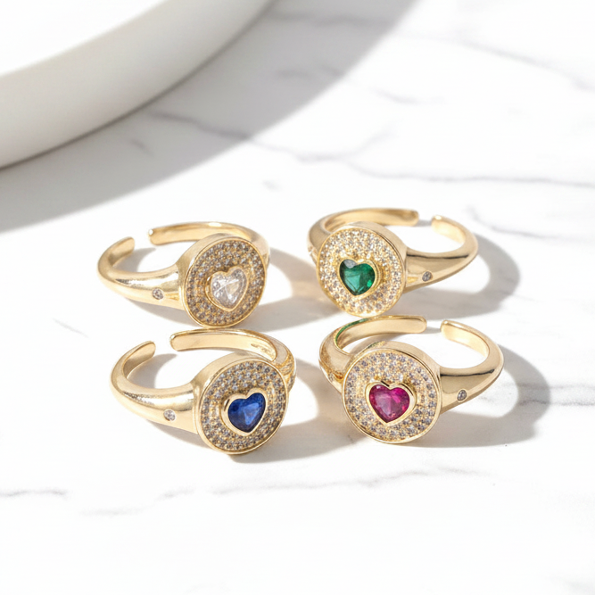 Set of gold rings with colored gemstones on a marble surface