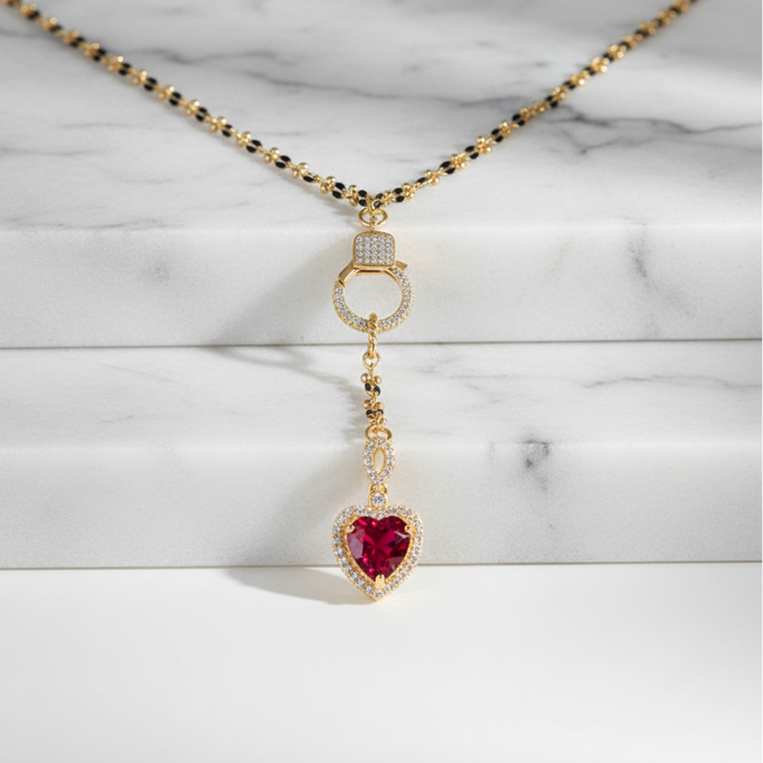 Necklace with a heart-shaped red gemstone pendant on a marble background