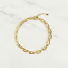 Gold chain anklet on a white marble surface